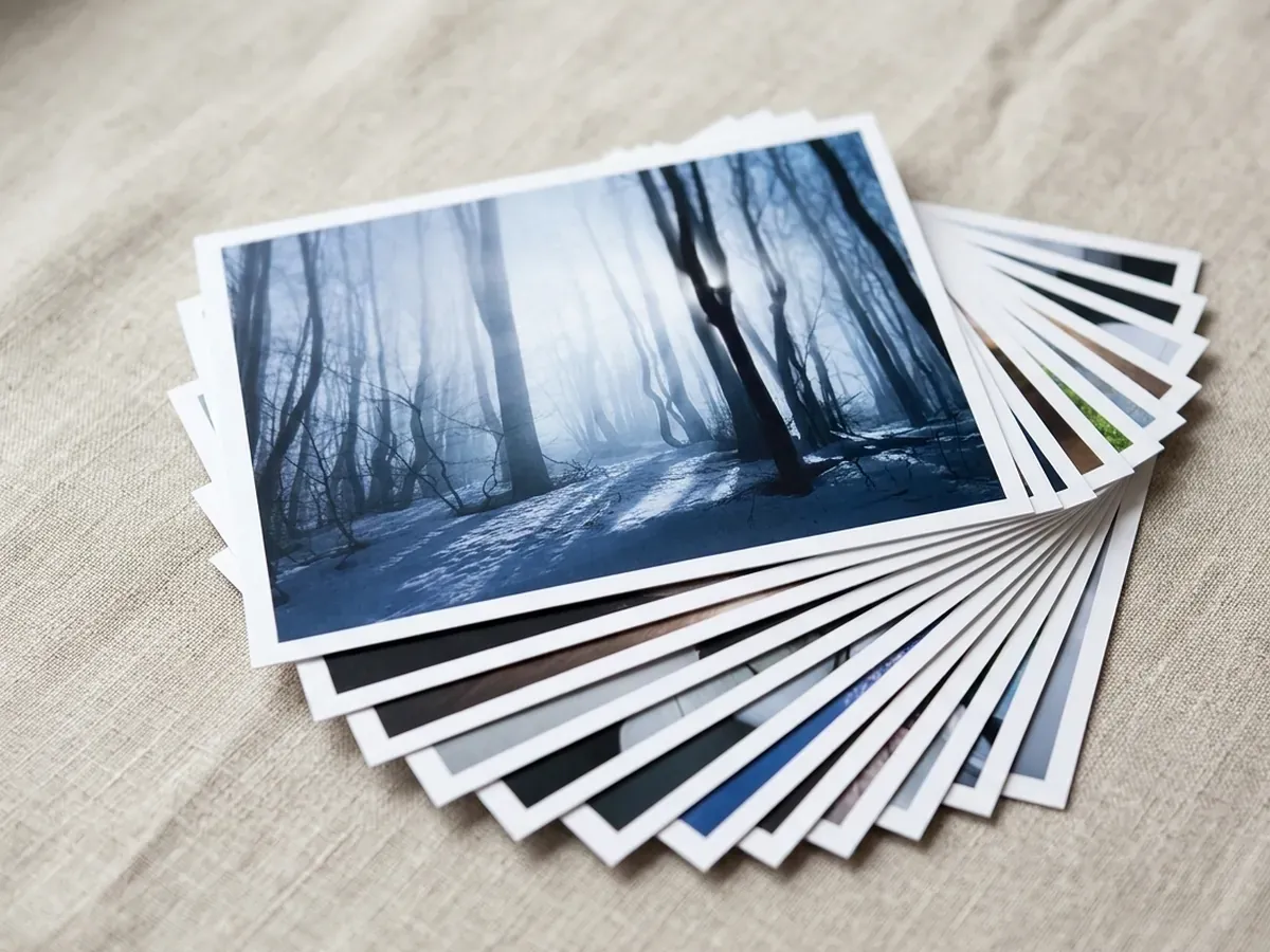 Odbitki fotograficzne rozłożone wachlarzem na lnianym obrusie